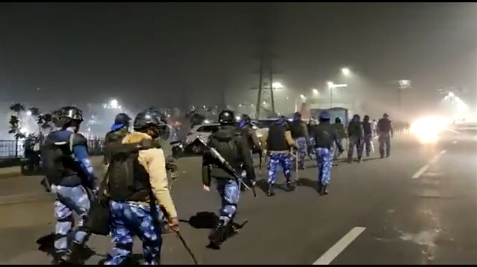 Security personnel conduct a flag march at Ghazipur border
