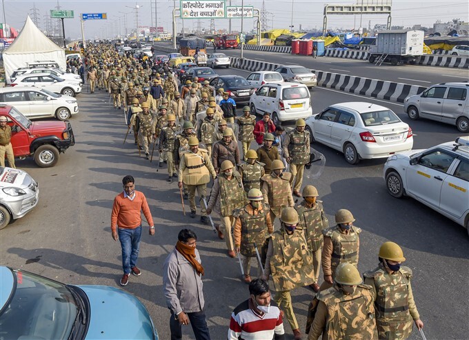 Security personnel conduct a flag march at Ghazipur border