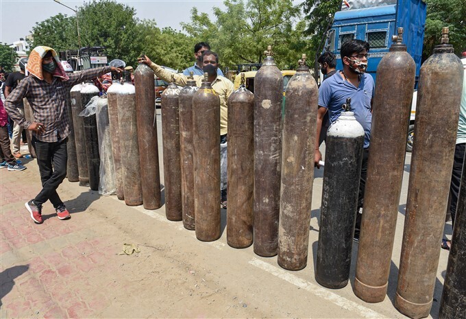 കൊവിഡ് രണ്ടാം തരംഗത്തിനിടെ ഉറ്റവരുടെ ജീവന്‍ രക്ഷിക്കുന്നതിനായി ഓക്‌സിജന്‍ സിലിണ്ടറിനായി വരിനില്‍ക്കുന്നവര്‍, ചിത്രങ്ങള്‍