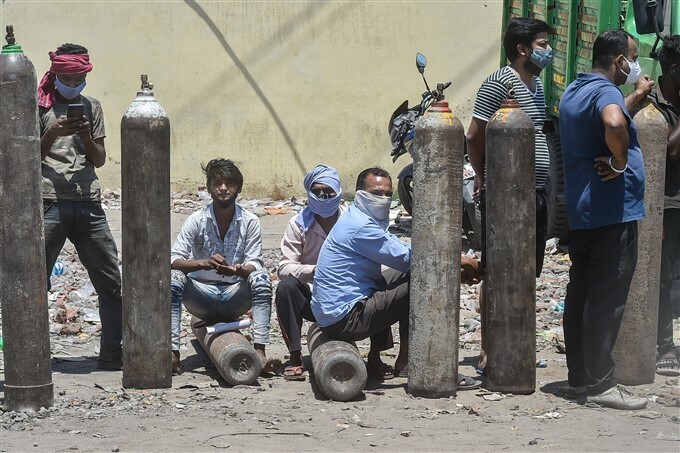 കൊവിഡ് രണ്ടാം തരംഗത്തിനിടെ ഉറ്റവരുടെ ജീവന്‍ രക്ഷിക്കുന്നതിനായി ഓക്‌സിജന്‍ സിലിണ്ടറിനായി വരിനില്‍ക്കുന്നവര്‍, ചിത്രങ്ങള്‍