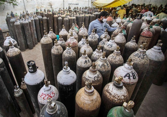 കൊവിഡ് രണ്ടാം തരംഗത്തിനിടെ ഉറ്റവരുടെ ജീവന്‍ രക്ഷിക്കുന്നതിനായി ഓക്‌സിജന്‍ സിലിണ്ടറിനായി വരിനില്‍ക്കുന്നവര്‍, ചിത്രങ്ങള്‍