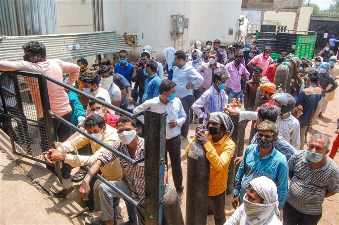 കൊവിഡ് രണ്ടാം തരംഗത്തിനിടെ ഉറ്റവരുടെ ജീവന്‍ രക്ഷിക്കുന്നതിനായി ഓക്‌സിജന്‍ സിലിണ്ടറിനായി വരിനില്‍ക്കുന്നവര്‍, ചിത്രങ്ങള്‍