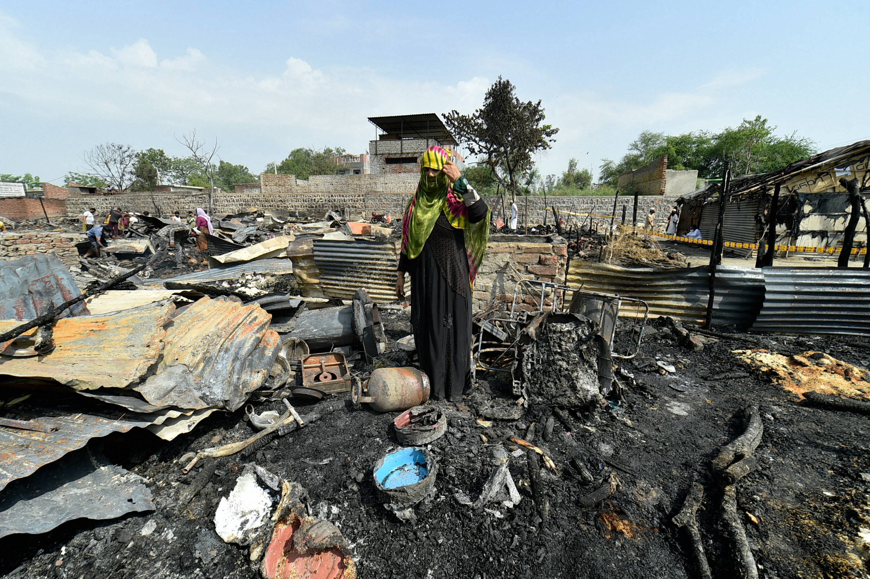തീപിടുത്തമുണ്ടായ ദില്ലിയിലെ റോഹിംഗ്യന്‍ ക്യാംപില്‍ അവശേഷിപ്പുകള്‍ തിരയുന്ന അഭയാര്‍ത്ഥി- ചിത്രങ്ങള്‍