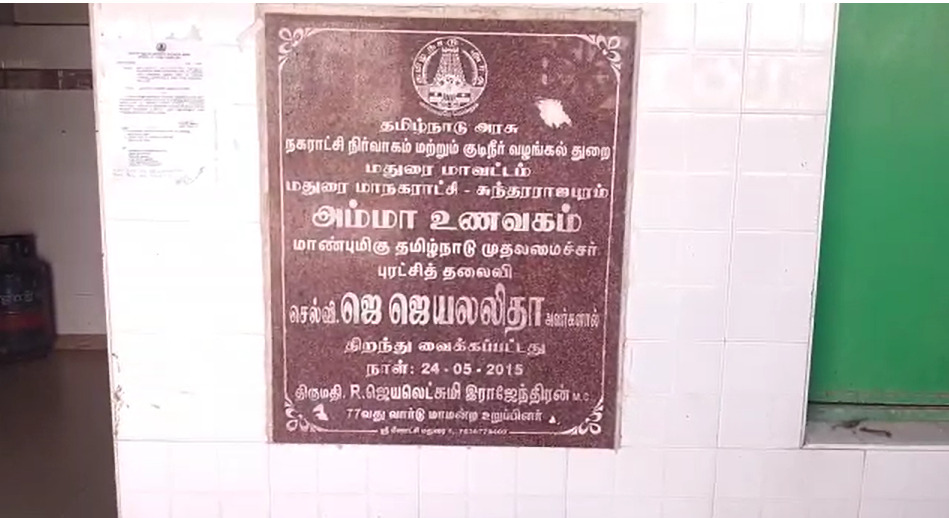 மதுரையில் உள்ள அம்மா உணவகத்தின் பெயர் பலகையில் முன்னாள் முதல்வர் கருணாநிதியின் புகைப்படம்...! மதுரையில் பரபரப்பு!  