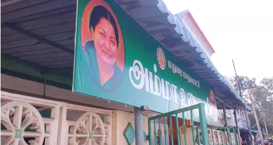 மதுரையில் உள்ள அம்மா உணவகத்தின் பெயர் பலகையில் முன்னாள் முதல்வர் கருணாநிதியின் புகைப்படம்...! மதுரையில் பரபரப்பு!  