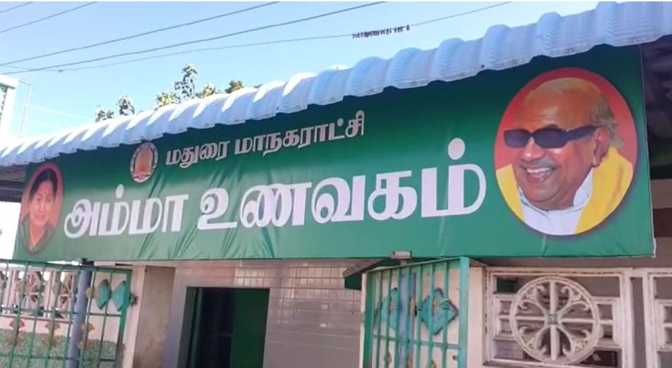 மதுரையில் உள்ள அம்மா உணவகத்தின் பெயர் பலகையில் முன்னாள் முதல்வர் கருணாநிதியின் புகைப்படம்...! மதுரையில் பரபரப்பு!  