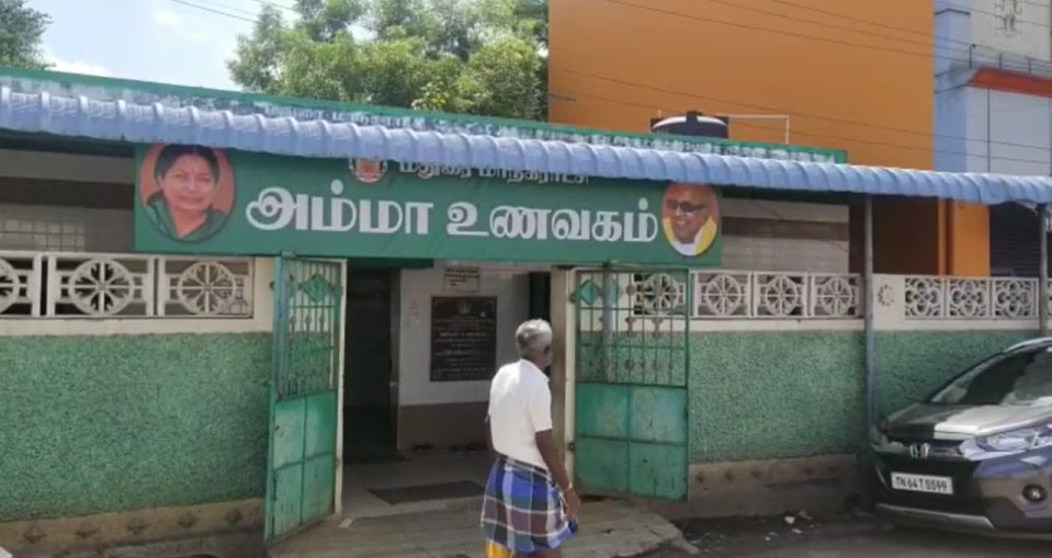 மதுரையில் உள்ள அம்மா உணவகத்தின் பெயர் பலகையில் முன்னாள் முதல்வர் கருணாநிதியின் புகைப்படம்...! மதுரையில் பரபரப்பு!  