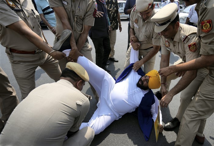 AAP worker being detained during a protest at ITO against the arrest of CM Arvind Kejriwal.