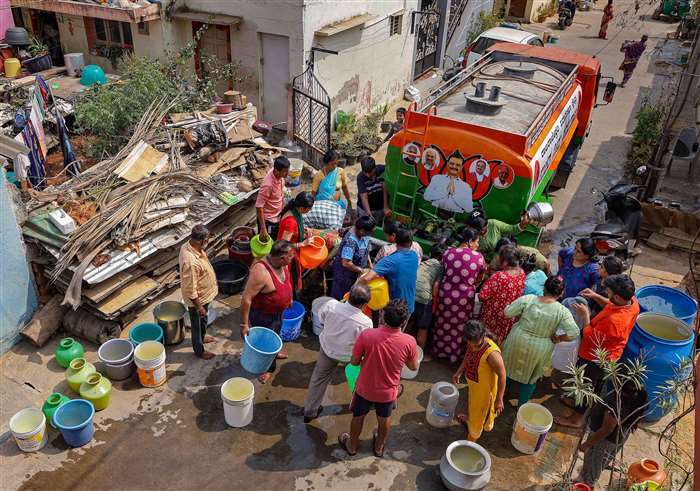 People collect free drinking water from a tanker due to water crisis at Bangarappa Nagar, in Bengalu