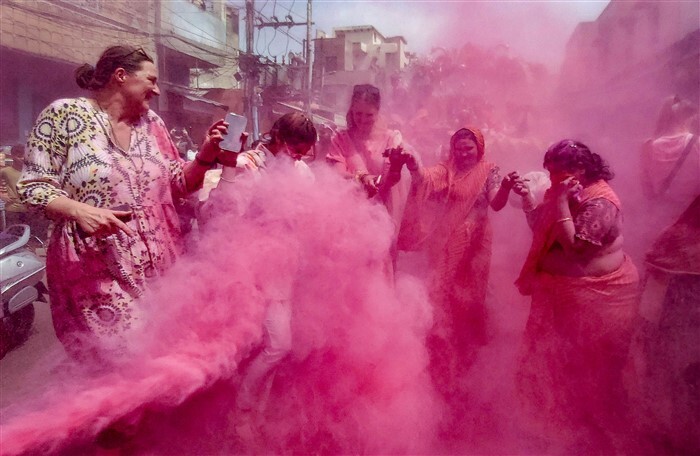 People play with colours ahead of the festival of Holi