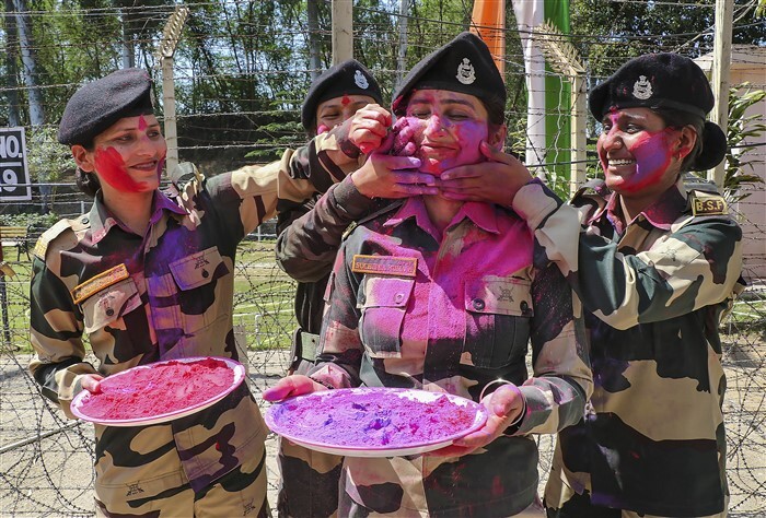 BSF personnel apply colours on each other during Holi celebrations at the India-Pakistan border