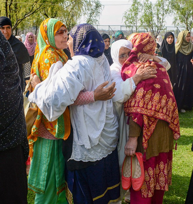 Muslim women greet each other on the ocassion of Eid-al-Fitr, at the historic Aali Masjid Eidgah, in Srinagar