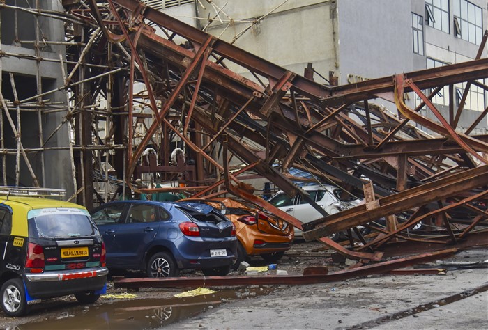 Damaged cars after an under-construction metal parking tower.