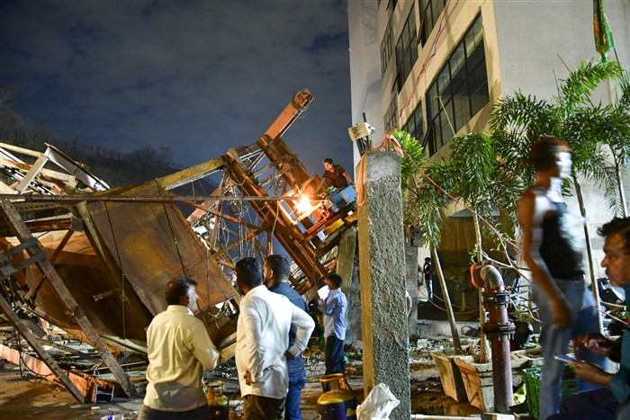 Restoration work underway after an under-construction metal parking tower collapsed on a road due to strong winds and rain.