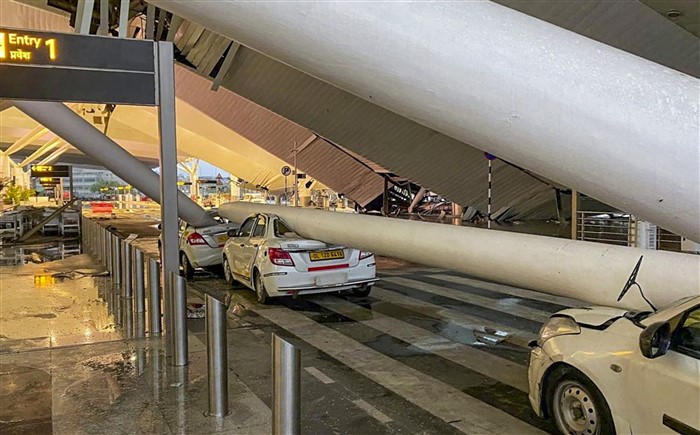 Vehicles are crushed after a portion of the roof at the Delhi airport's Terminal-1 collapsed amid heavy rainfall, in New Delhi.