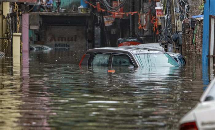 Vehicles are submerged at a waterlogged road near Sarai Kale Khan area after rain, in New Delhi.