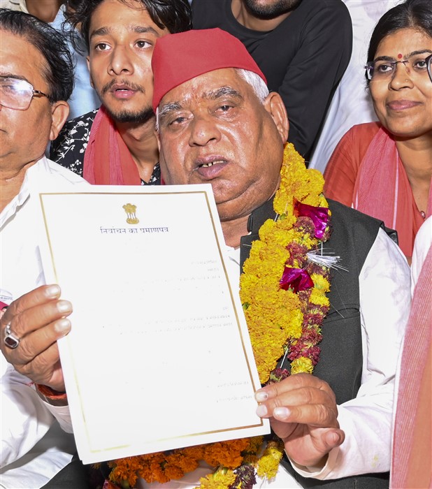 Samajwadi Party (SP) candidate from Faizabad constituency Awadhesh Prasad shows his certificate after winning the Lok Sabha elections, at Government Inter College, in Ayodhya.