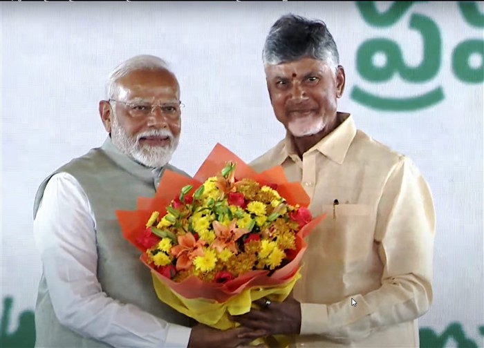 Prime Minister Narendra Modi greets Nara Chandrababu Naidu after he was sworn-in as the Chief Minister of Andhra Pradesh, at a ceremony in Vijayawada.