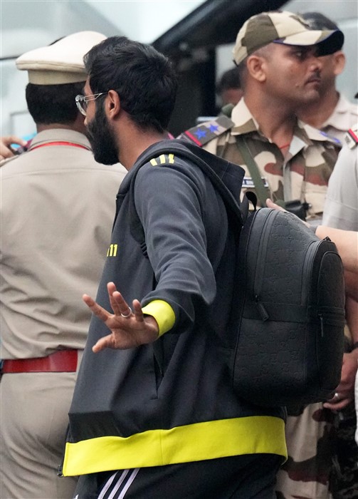Indian cricketer Jasprit Bumrah waves upon his arrival at New Delhi airport.
