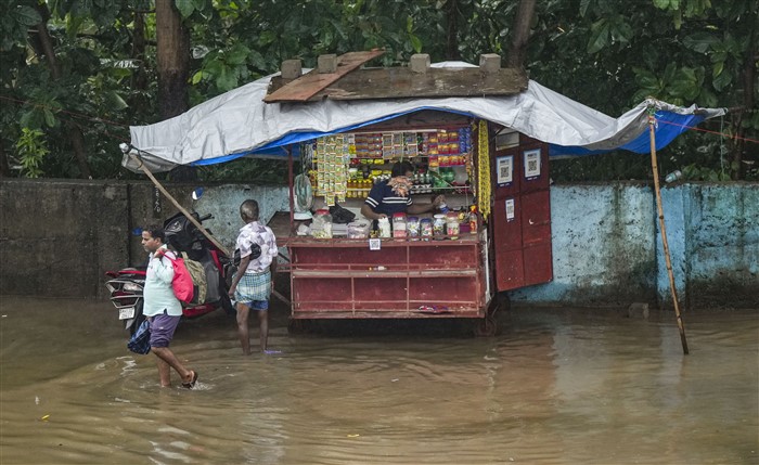 A stall is covered with a sheet during rains, seen on a waterlogged street, in Mumbai.