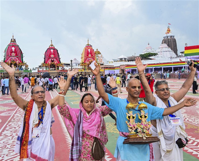 Devotees stand near the chariots carrying the idols of Lord Jagannath, Lord Balabhadra and Goddess Subhadra during the annual ‘Rath Yatra’, in Puri.