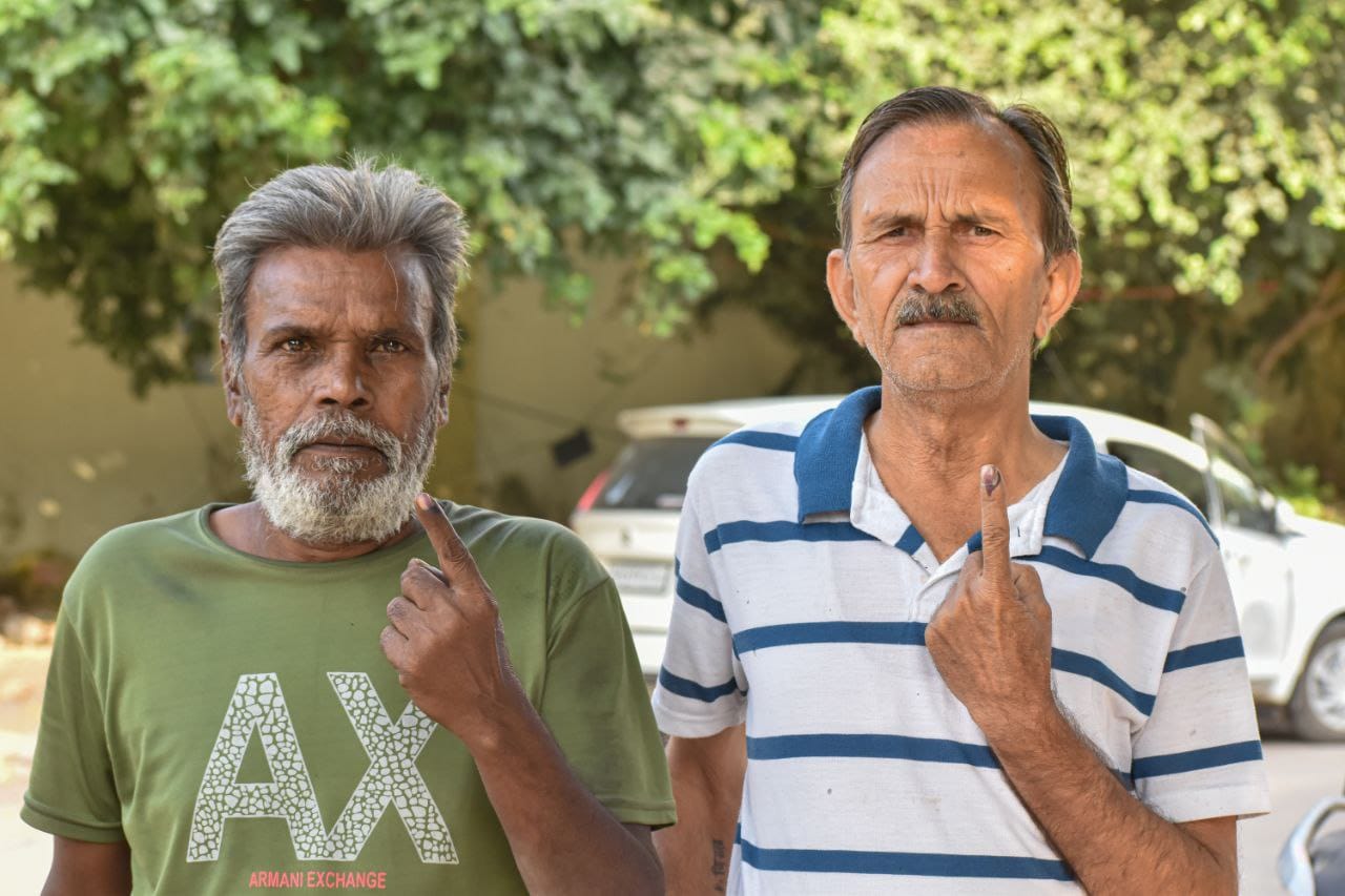 Individuals proudly display their marked fingers after casting their votes.