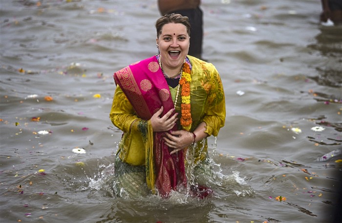 A foreign devotee takes a holy dip at Sangam on the first day of Maha Kumbh Mela 2025, in Prayagraj, Uttar Pradesh, Monday, Jan. 13, 2025.