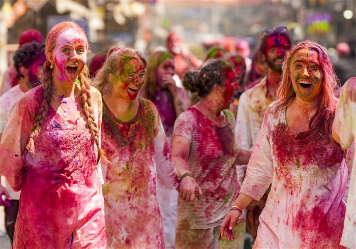 Foreign tourists participate in Holi celebrations along with locals in Paharganj, in New Delhi, Friday, March 14, 2025.
