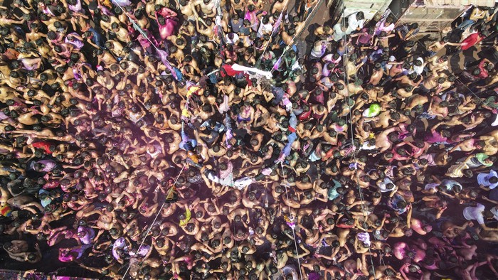 A drone shot shows people participating in 'Kapdafaad Holi', at Loknath Chauraha, in Prayagraj, Friday, March 14, 2025.