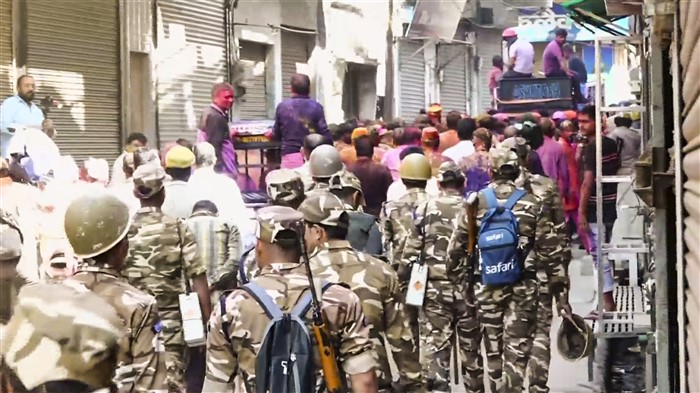 People participate in a Holi procession amid tight security arrangements, in Sambhal, Friday, March 14, 2025.