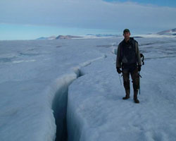 Scientist Derek Mueller stands by a crack in the ice sheet