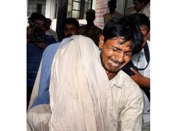 A man mourns as he holds his dead daughter in Patna Medical College & Hospital after at least 20 children died
