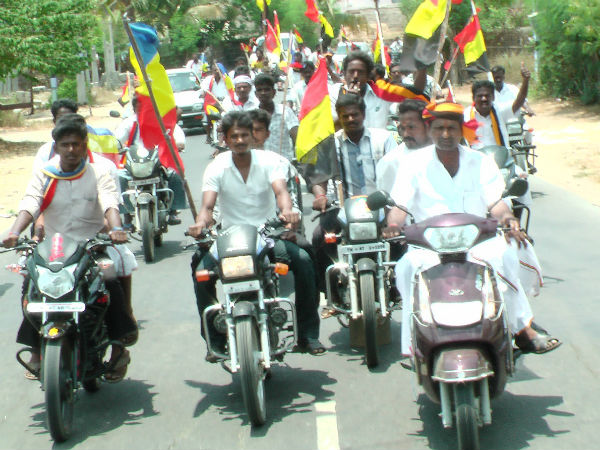 தொண்டர்கள் புடை சூழ பைக் ஓட்டியபடி