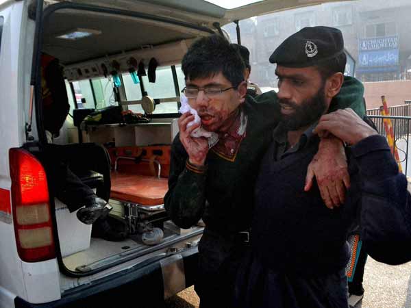 A hospital security guard helps a student injured in the shootout at a school under attack by Taliban gunmen A hospital security guard helps a student injured in the shootout at a school under attack by Taliban gunmen