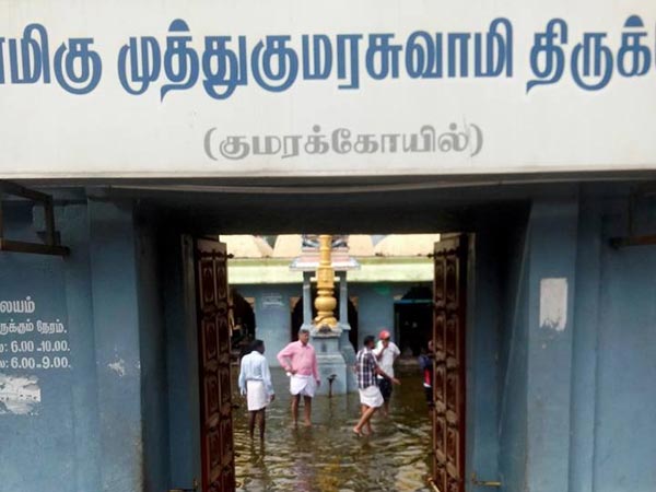 Islamic party cadres help to drain flood water from a Murugan temple