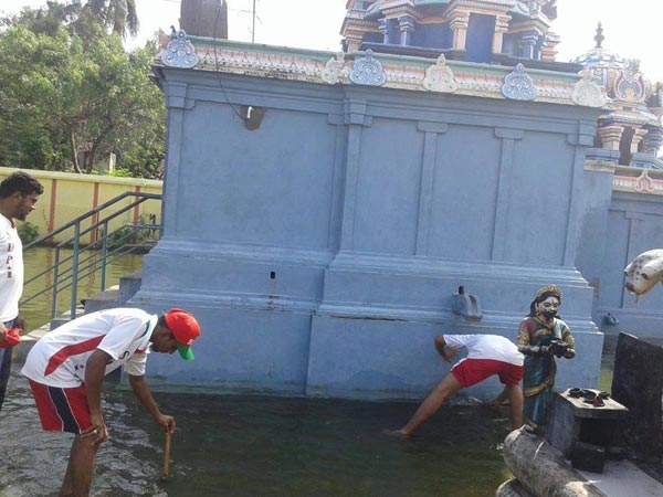Islamic party cadres help to drain flood water from a Murugan temple