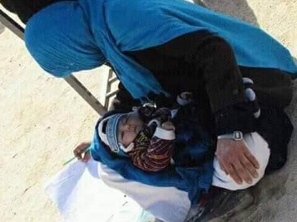 afghan woman writes exam while nursing her baby