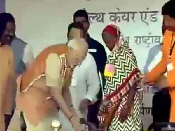 PM Narendra Modi present a pair of slippers to a bare footed lady PM Narendra Modi present a pair of slippers to a bare footed lady