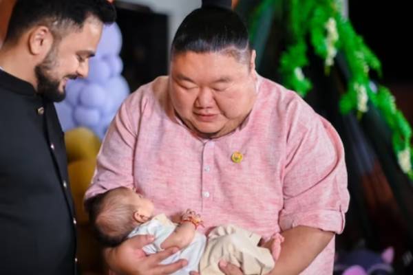 கைக்குழந்தை ஒன்றை கையில் வைத்தபடி 