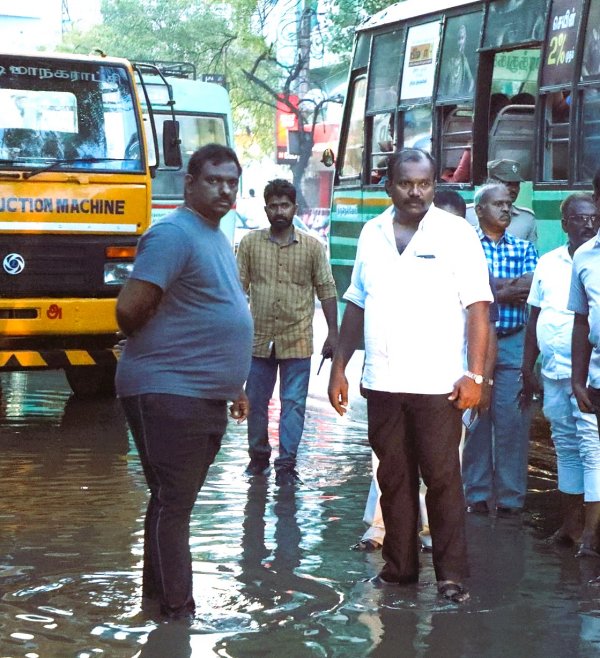 Tuticorin Mayor Jagan Periyasamy, holding an umbrella in the pouring rain, has been inspection in city Tuticorin Mayor Jagan Periyasamy, holding an umbrella in the pouring rain, has been inspection in city
