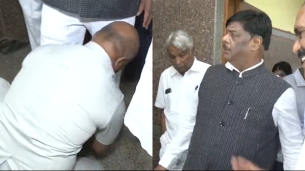 Karnataka Social Welfare Minister HC Mahadevappa gets his shoes put on by his gunman 