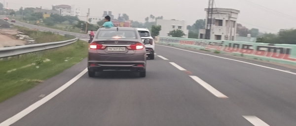 The car driver drove at high speed with the sunroof open and the children standing 