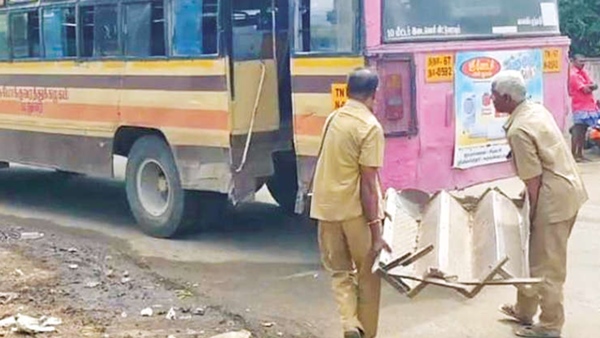 Driver and conductor lifting the bus ladder from the road in government bus in Rajapalayam