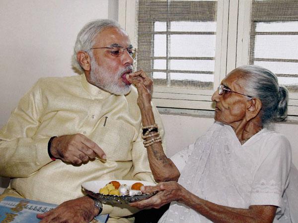 తన తల్లి హీరా బా స్వీట్ తినిపిస్తున్న దృశ్యం