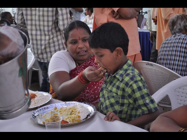 చిన్నారికి ముద్ద పెడుతూ...