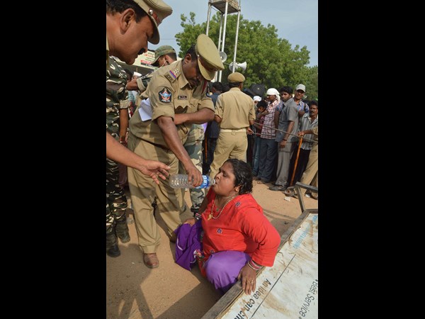 కిందపడి పోయిన మహిళకు నీళ్లు తాగిస్తూ..