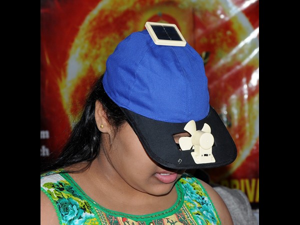 సౌర టోపీ ఫ్యాన్ ధరించిన యువతి