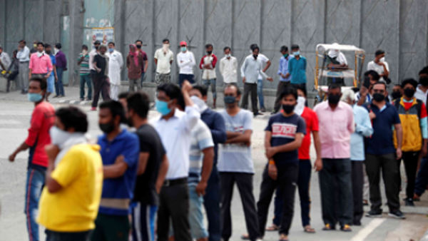  గొడుగులు, మాస్కులు , సామాజిక దూరం పాటిస్తూ క్యూలో నిల్చున్న మద్యం ప్రియులు 