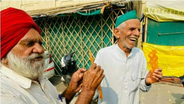 స్వీట్స్ పంచుకుంటూ డ్యాన్సులు చేస్తున్న రైతులు 