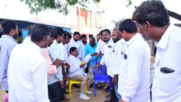  Put a chair under the tree and talk to people.The minister is waving even in the rains.